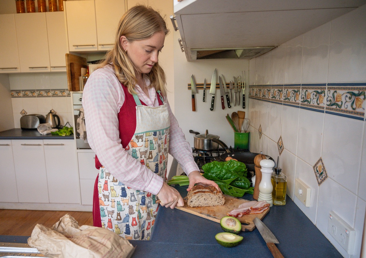 Beccy slicing bread in the kitchen