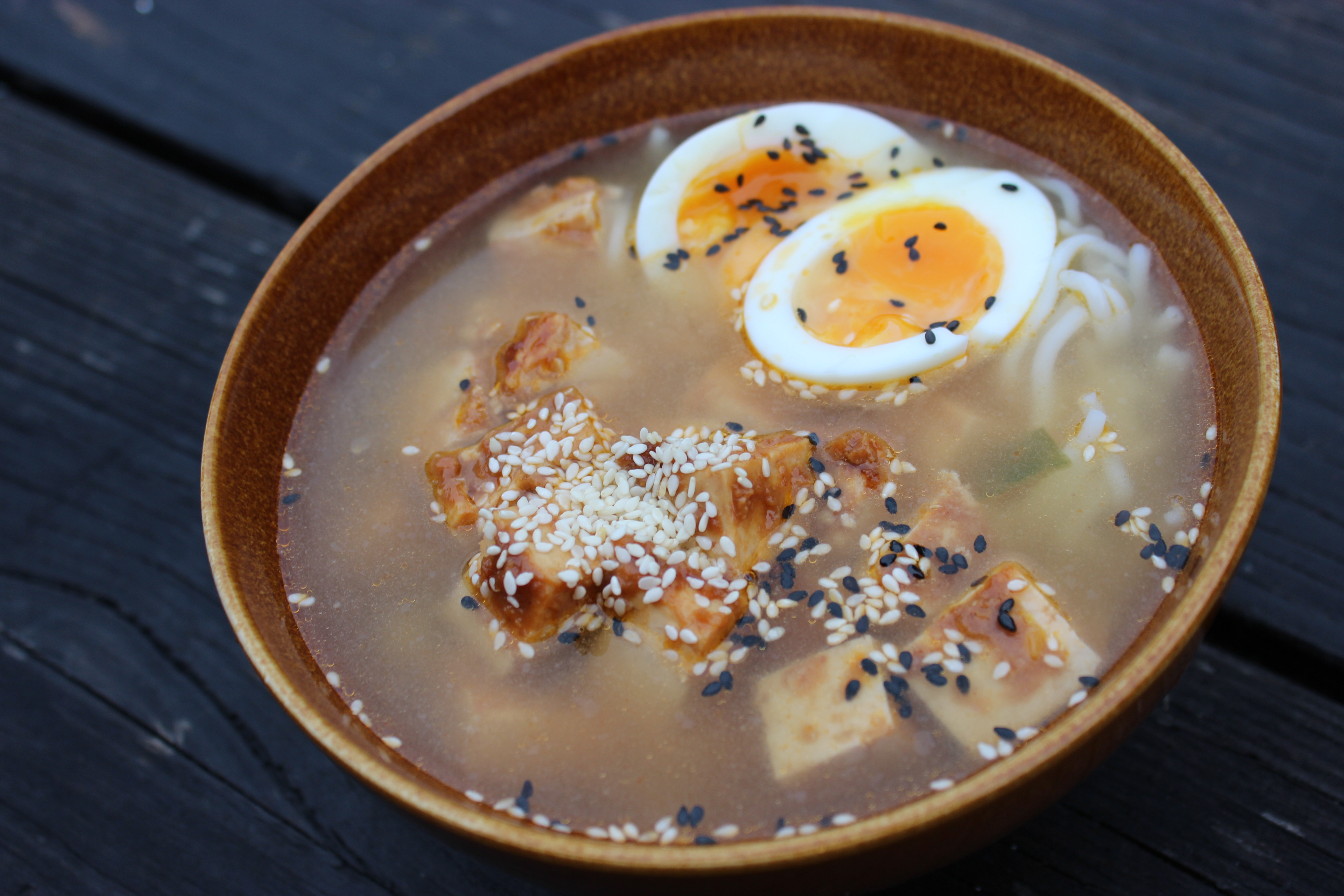 gut healing tofu ramen noodle soup with a boiled egg and sesame seeds
